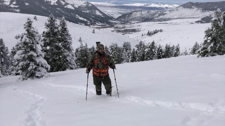 hiking through deep snow with full outdoor gear system in use