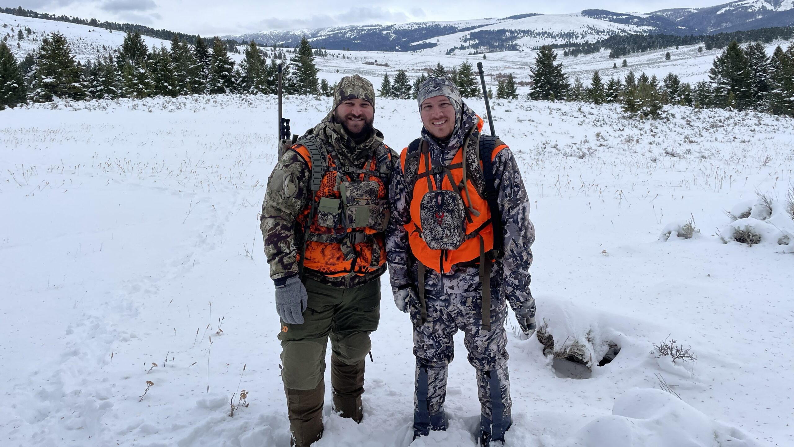 two hunters using different outdoor gear systems in snowy backcountry conditions