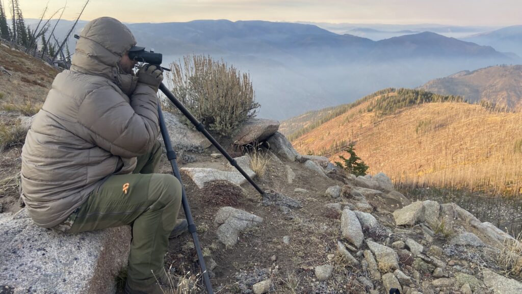 hunter glassing with binoculars in low light during late season hunt
