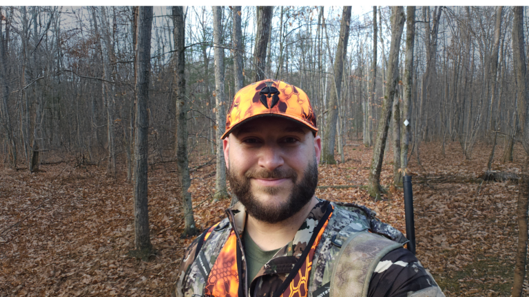 Hunter wearing First Lite Wick base layer under hunting vest while moving through woods