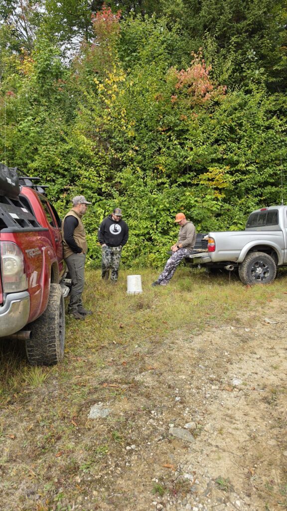 Bear-hunting crew gathered beside guide trucks in Rangeley